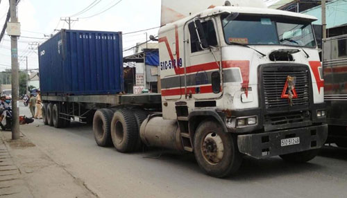 Bé trai gào khóc khi mẹ nằm bất động dưới gầm container - 1