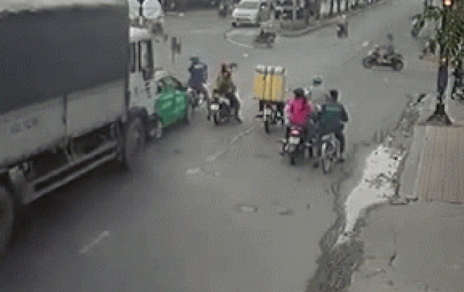 SỐC: Chờ đèn đỏ, lái xe máy bị xe tải tông gián tiếp suýt mất mạng - 1