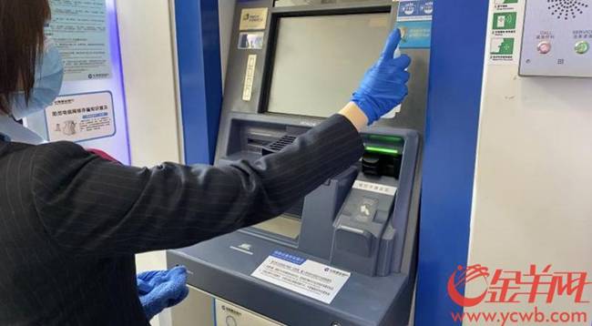 Một nữ nhân viên vệ sinh máy ATM để ngăn không có virus bám lại trên máy.