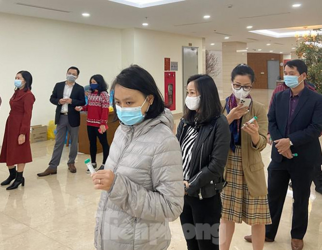 Dân văn phòng xếp hàng lấy mẫu xét nghiệm COVID-19 trong ngày đầu tiên đi làm - 4