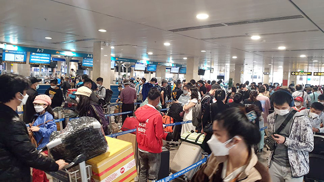 Sân bay Tân Sơn Nhất đông nghịt khách về quê ăn Tết - 1
