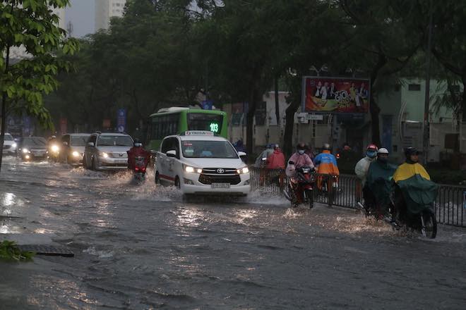 TP.HCM mưa mù trời, nước đổ như trút, người dân bật đèn chạy xe giữa ban ngày - 1