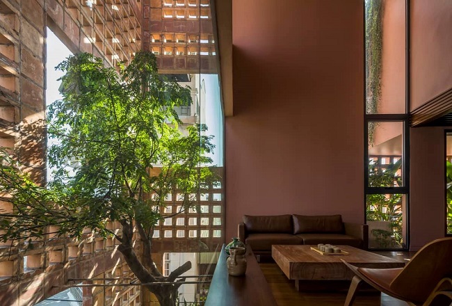 Không gian nội thất bên trong được thiết kế thoáng đãng, với những ô kính lớn tạo nên các khung hình cho người sống trong ngôi nhà có thể bắt trọn được phần thiên nhiên cây xanh bao phủ xung quanh, cảm nhận các hiệu ứng ánh sáng được tạo ra bởi lớp tường gạch gốm phía bên ngoài. Ảnh: Hiroyuki Oki
