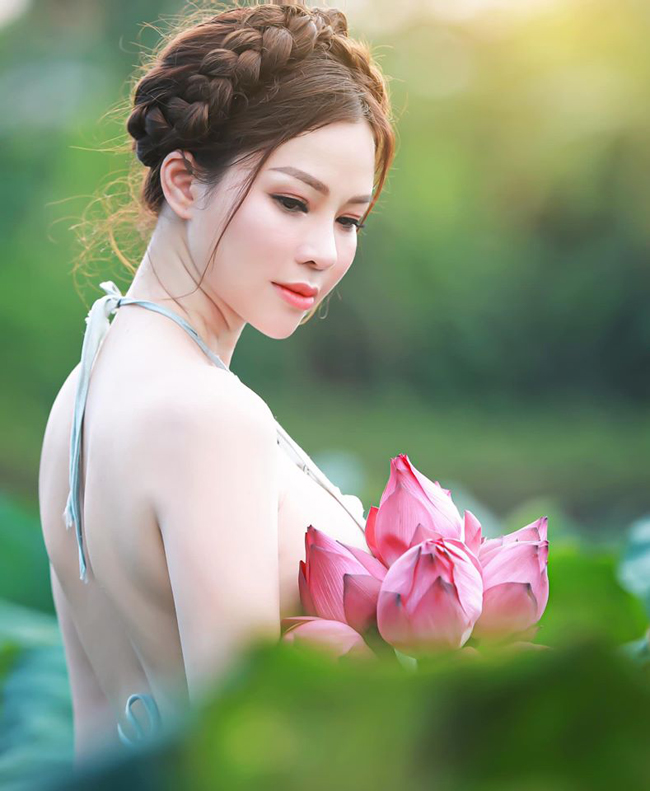 Yêu thích trang phục truyền thống nên con dâu tỷ phú Hoàng Kiều diện yếm đào tạo dáng bên bó sen hồng. Người đẹp gốc Bắc Ninh được khen ngợi vì vẻ đẹp nhẹ nhàng, trong trẻo.
