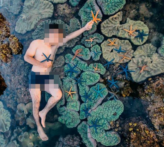 Nam thanh niên nằm lên rạn san hô, vớt sao biển để chụp ảnh bị dân mạng chỉ trích dữ dội - 1