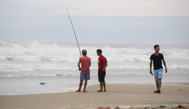 Mặc sóng lớn sau bão, người dân vẫn ra biển câu cá, chụp hình - 5