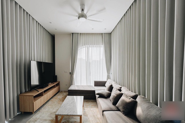 Phòng khách được thiết kế theo phong cách hiện đại và tối giản trong việc bài trí nội thất với tông màu ghi xám, hòa cùng màu nền là màu trắng tạo nên không gian ấm áp nhưng cũng rất sang trọng.
