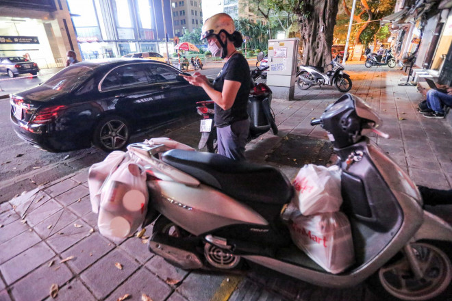 Người dân mặc áo mưa tiếp tế lương thực vào trung tâm thương mại bị phong toả - 8