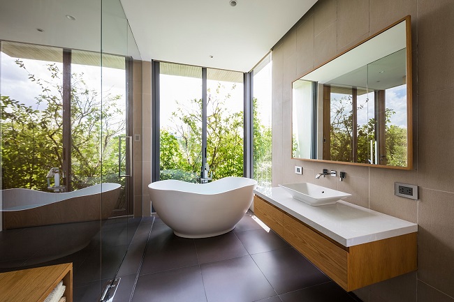 Nội thất phòng tắm đơn giản nhưng tinh tế, hiện đại, Dù là cửa kính nhưng vẫn đảm bảo được tính riêng tư nhờ “hàng rào” xanh ở phía ngoài. (Ảnh: Hiroyuki Oki)
