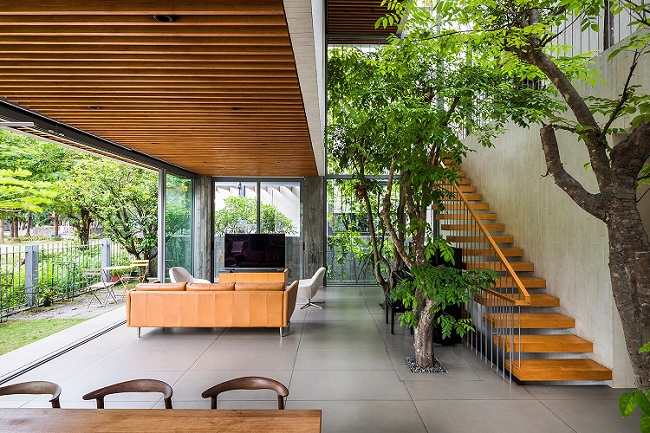 Ở tầng trệt, phòng khách được thiết kế theo hướng mở, giao hòa với cây cối bên ngoài. Các tầng trên, cây xanh cũng trở thành “nội thất” chính bao phủ khắp không gian. (Ảnh: Hiroyuki Oki)
