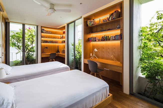 Khác với khu vực sinh hoạt chung, các phòng riêng như phòng ngủ được thiết kế như những khối vuông đặc, riêng tư và kín đáo hơn. Việc trồng cây ở cửa sổ giúp chặn ánh sáng mặt trời trực tiếp, cung cấp gió mát và làm sáng không gian bên trong. (Ảnh: Hiroyuki Oki)
