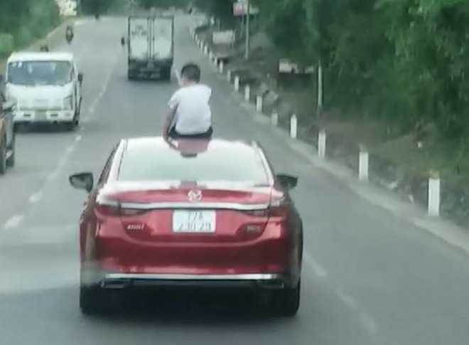 Phạt nặng nữ tài xế lái ô tô để con ngồi trên mui xe - 1