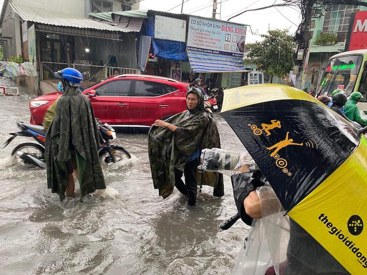 Sóng nước cuồn cuộn, người dân TPHCM “bơi” trên đường sau trận mưa lớn - 1
