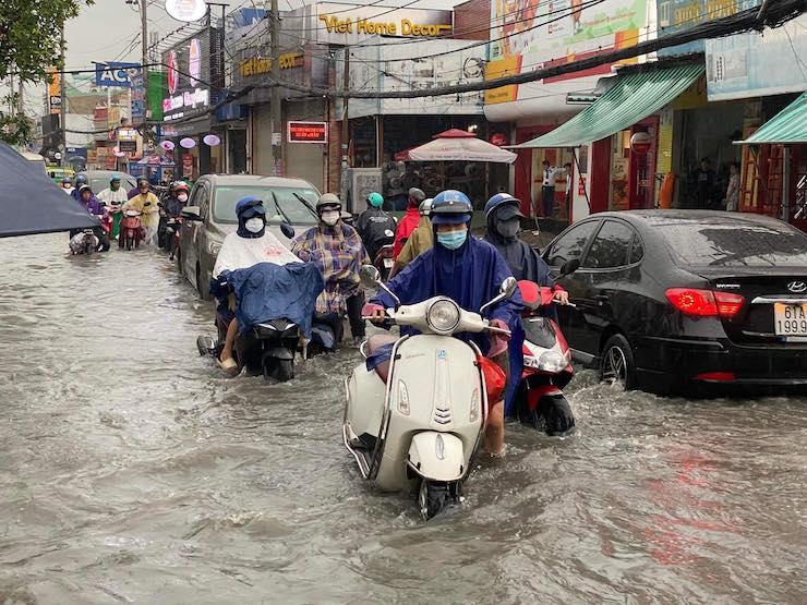Sóng nước cuồn cuộn, người dân TPHCM “bơi” trên đường sau trận mưa lớn - 7