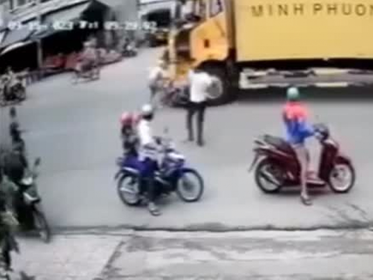 Clip: Đi vào "vùng cấm kỵ”, 2 người đi xe máy bị xe tải đè xuống gầm, may mắn thoát đại nạn