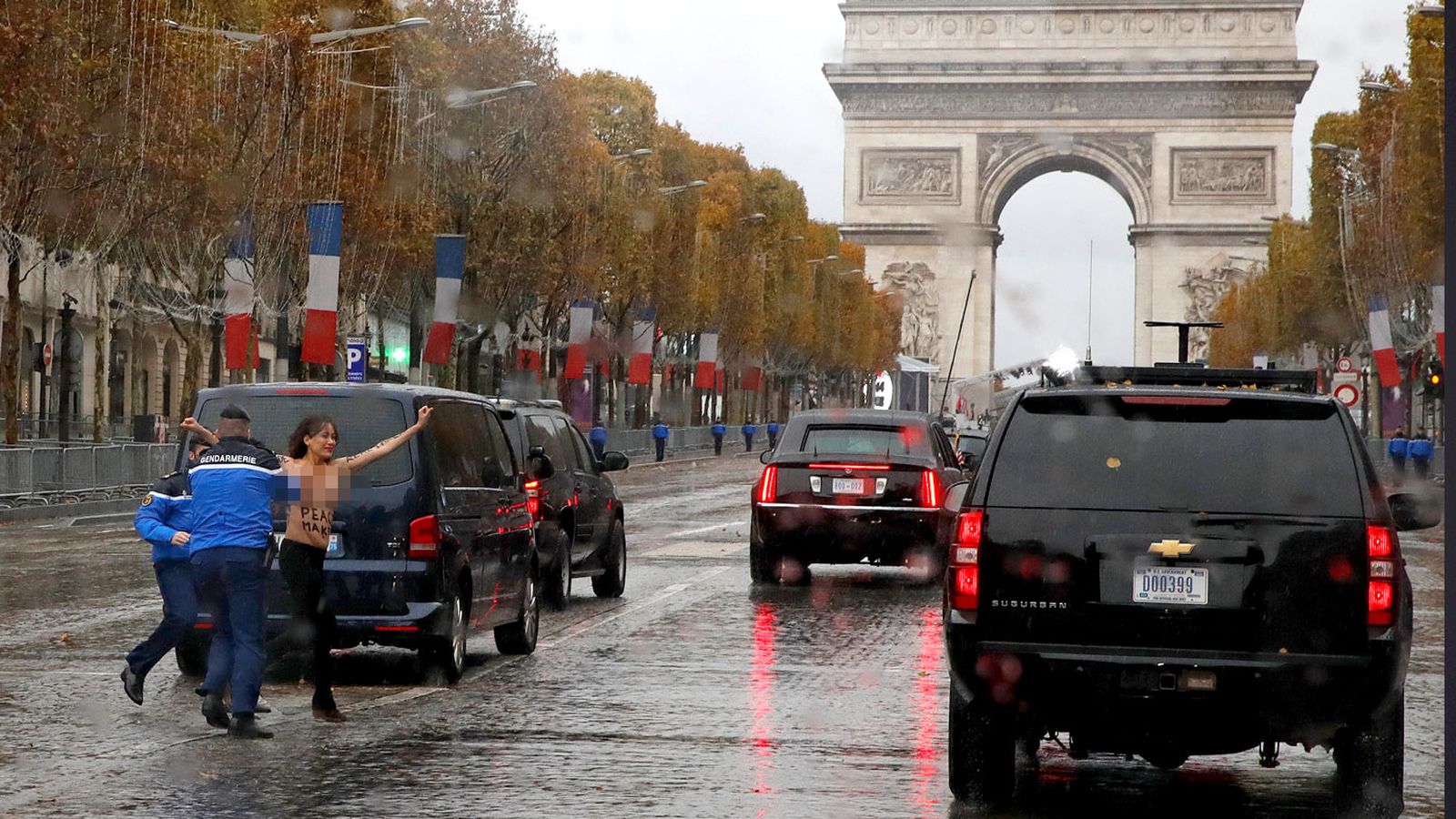 Video: Người phụ nữ ngực trần chặn đoàn xe hộ tống ông Trump ở Paris - 1