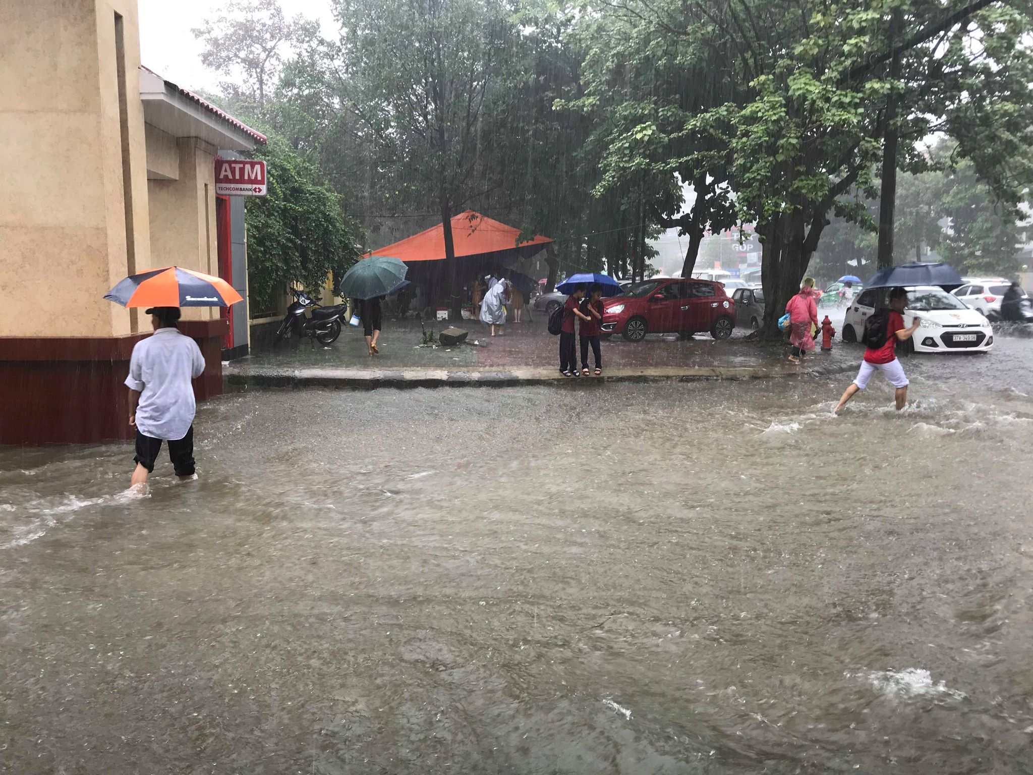 Mưa trắng trời, TP Vinh “biến” thành sông, học sinh lội nước ngang bụng về nhà - 1