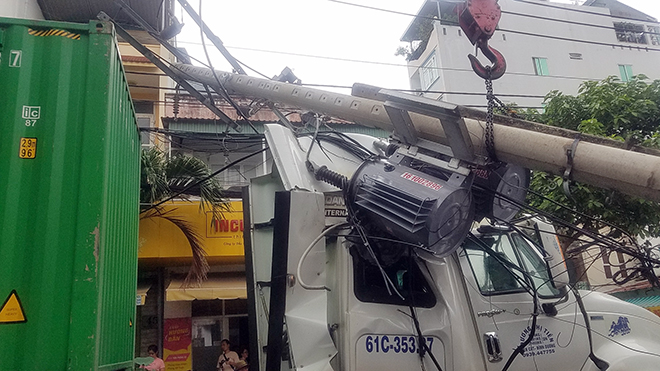 Vướng dây cáp, xe container kéo gãy 2 cột điện ở Sài Gòn - 2