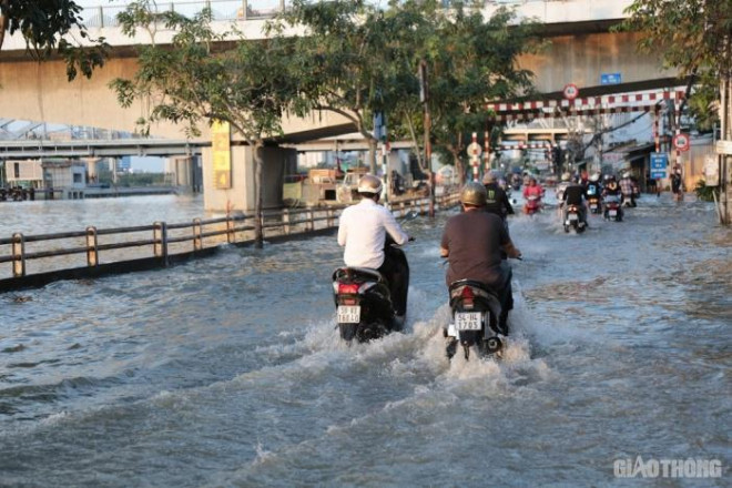 Triều cường đạt đỉnh, người dân TP.HCM vật vã lội "biển nước" về nhà - 4