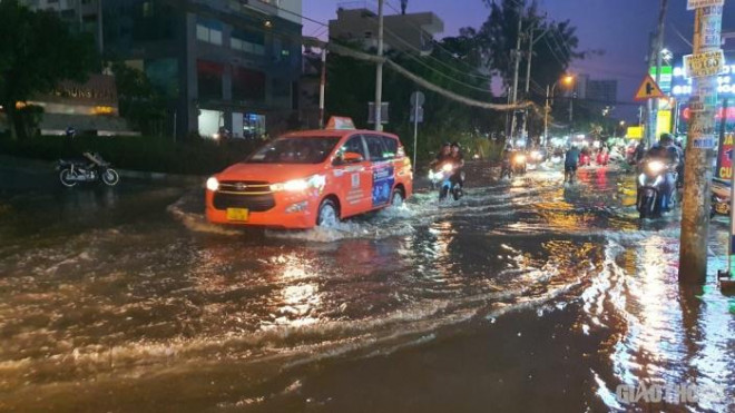 Triều cường đạt đỉnh, người dân TP.HCM vật vã lội "biển nước" về nhà - 10