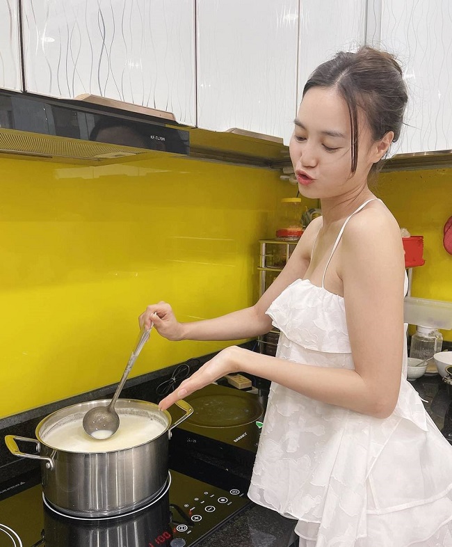 Ninh Dương Lan Ngọc mặc bộ đồ ở nhà màu trắng vào bếp.
