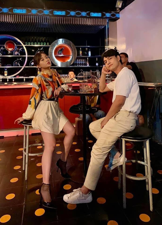Phương Oanh kết hợp áo sơ mi họa tiết với chân váy ngắn, vải lụa mềm mại đi bar, trong bộ phim Hương vị tình thân.
