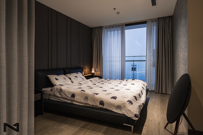 Phòng ngủ master với ban công lớn được thiết kế với gam màu tối nhưng hiện đại và vẫn giữ được sự ấm áp. (Ảnh: Abluebird Photography)
