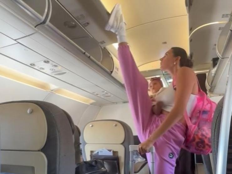 Người đẹp Nga cao 1m83, tay bế con, chân đóng cửa khoang hành lý trên máy bay